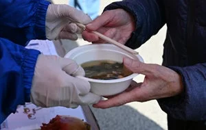 試食会で味噌汁を手渡す様子