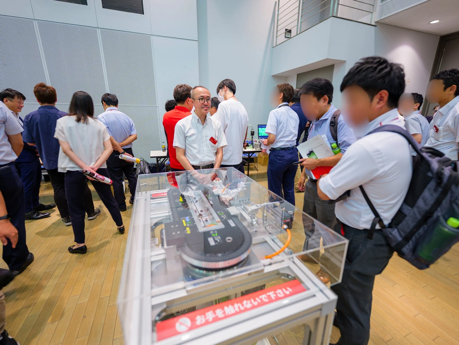 機械の展示物を囲んで説明を聞いている様子