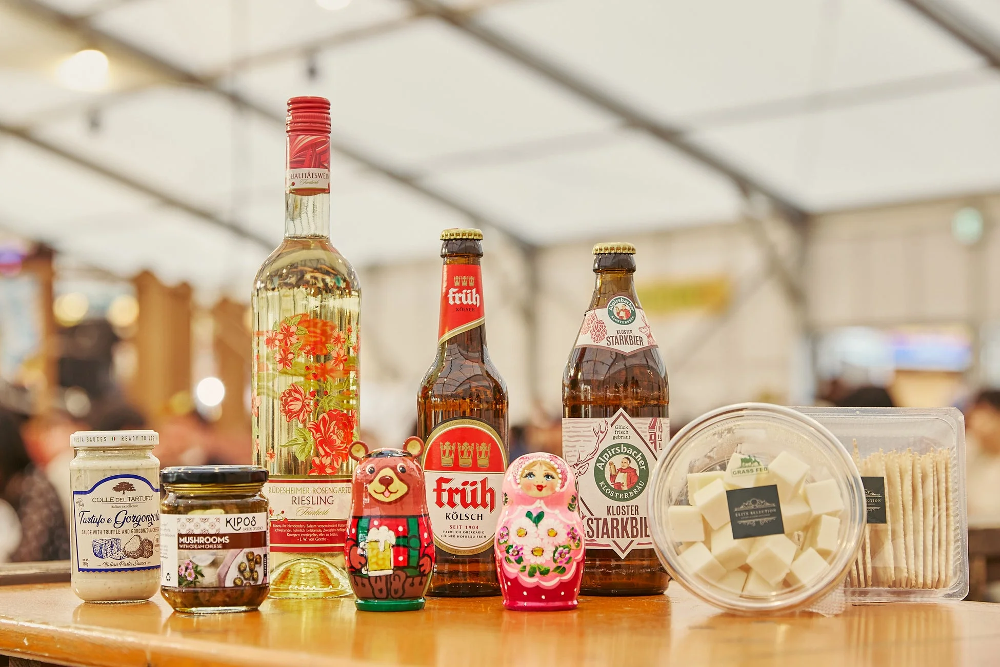 ドイツワイン、ビール、イタリアのトリュフソース、ギリシャのマッシュルーム、チーズ、クラッカーなど、国際色豊かな輸入食品や飲料が並んだテーブル