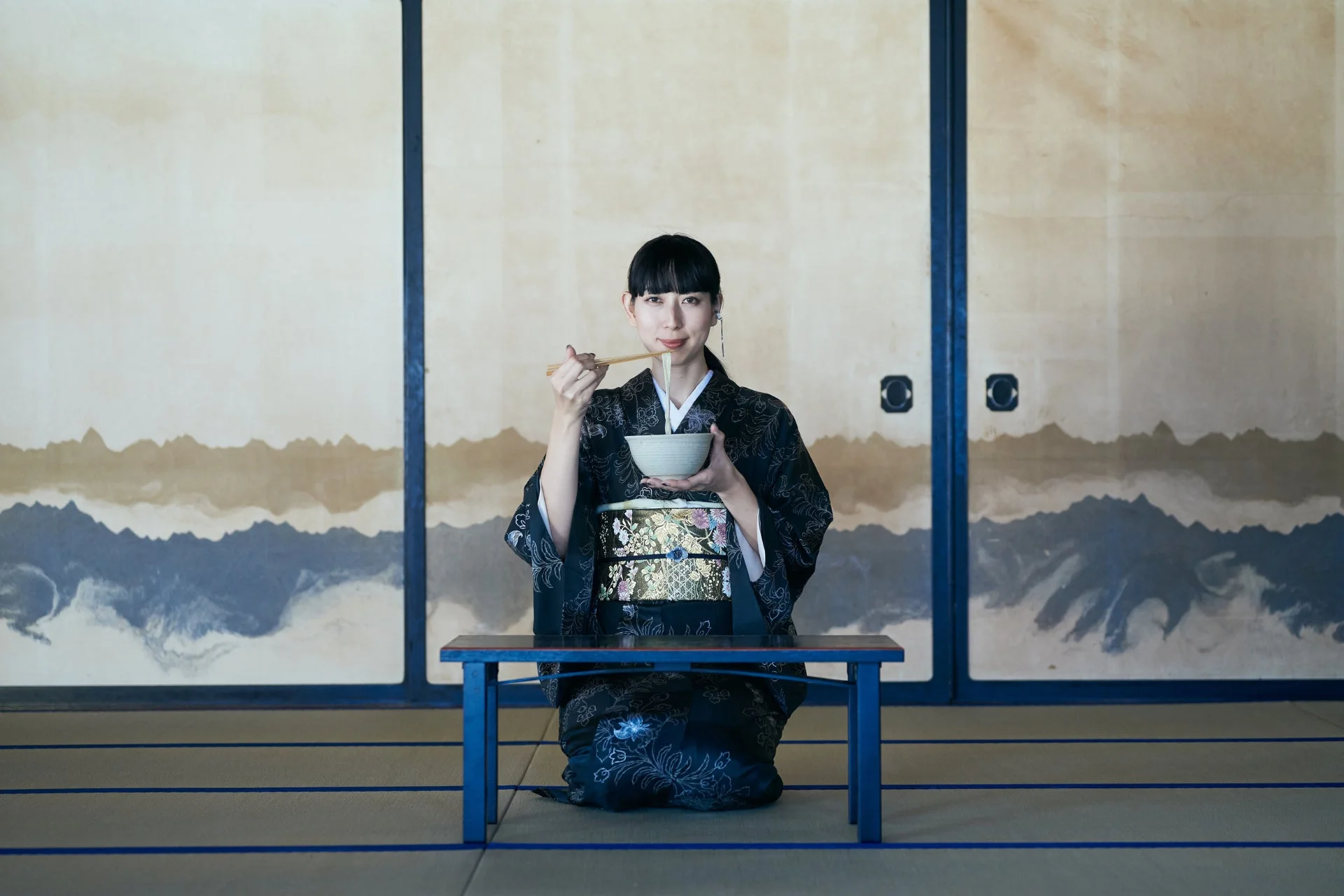 着物を着た女性が和室で食事