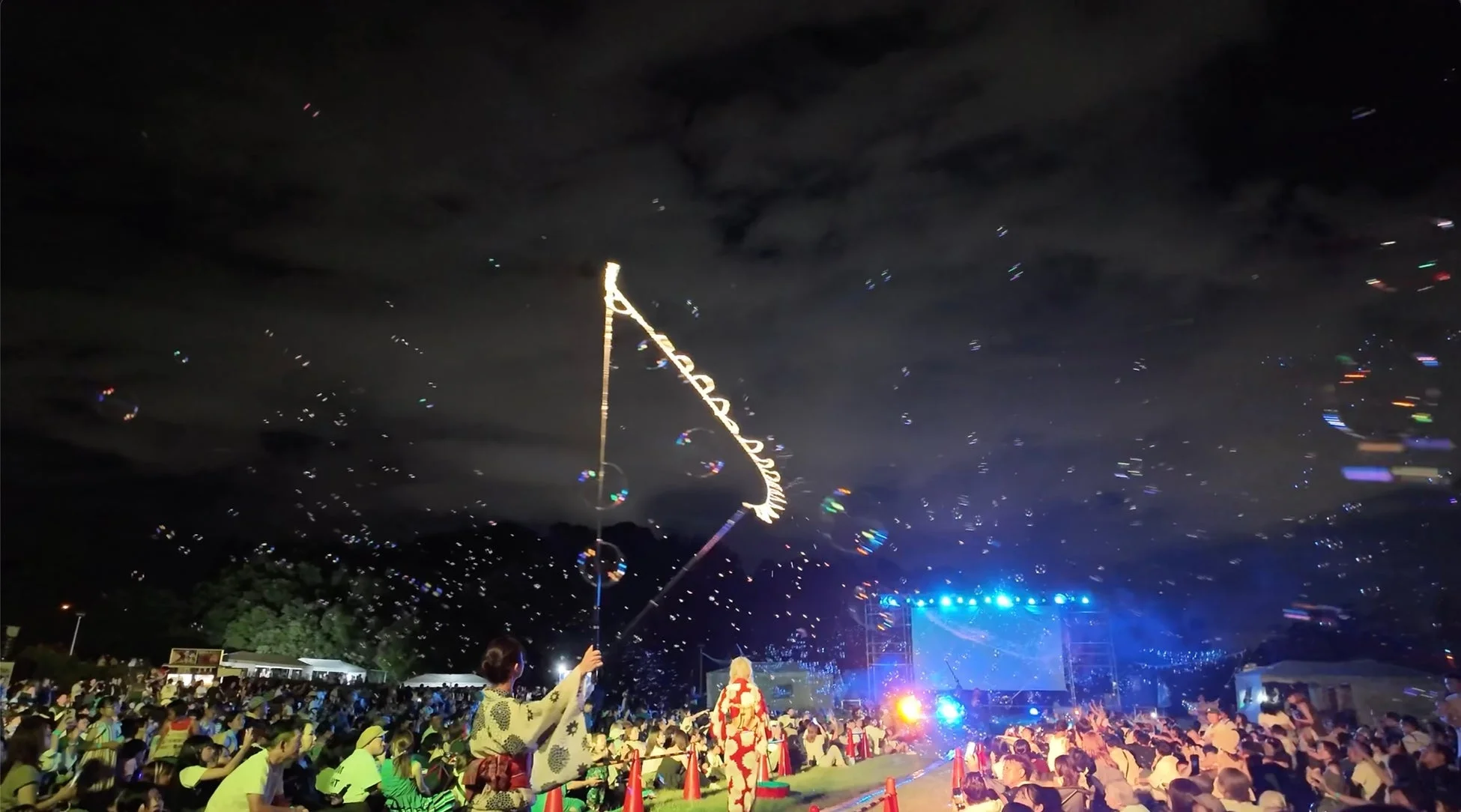 夜のイベントでシャボン玉を楽しむ人々