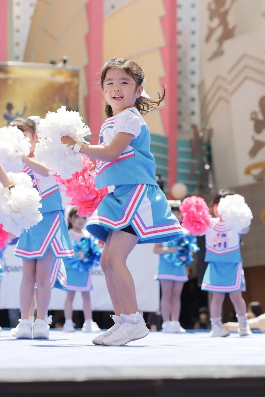 幼い女の子たちのチアリーディング、青と白ユニフォーム