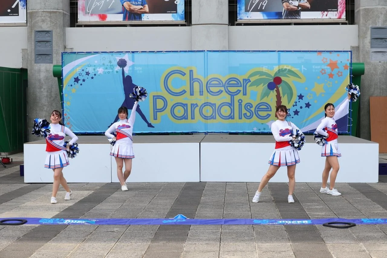 屋外ステージでパフォーマンスするチアリーダー