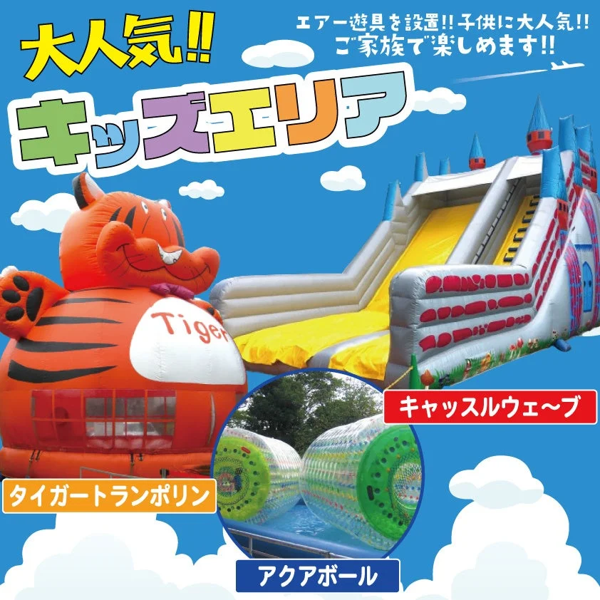「キッズエリア」の広告画像です。タイガートランポリンやキャッスルウェーブ（滑り台）、アクアボールといったエアー遊具が設置されており、子供に大人気で家族全員で楽しめることが強調されています。青空の下、屋外での楽しいアクティビティが描かれています。