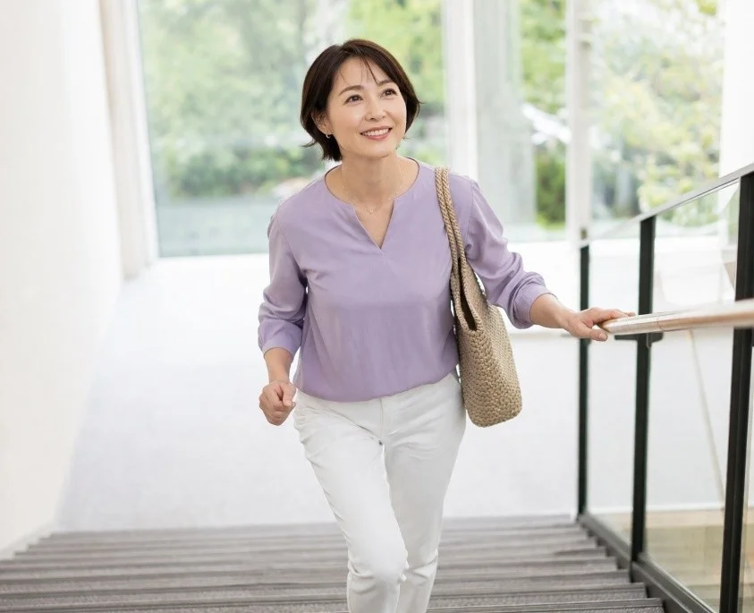 笑顔で階段を上る女性