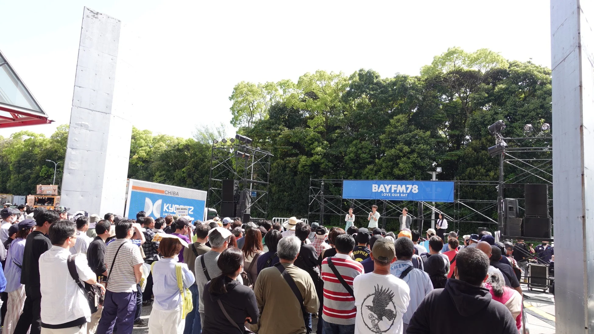 屋外ステージでイベントを楽しむ観客たち