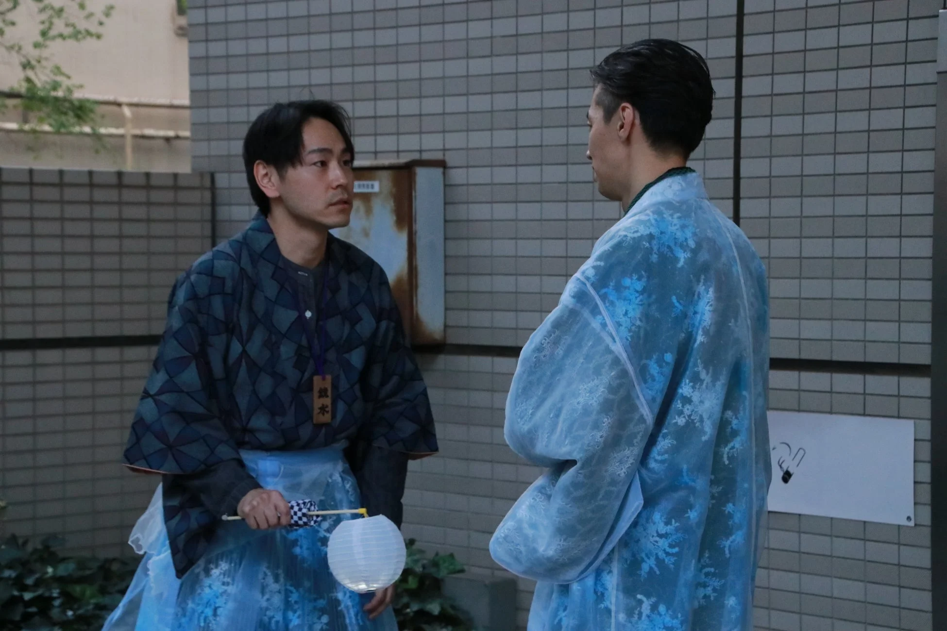 和装の男性二人が会話している様子