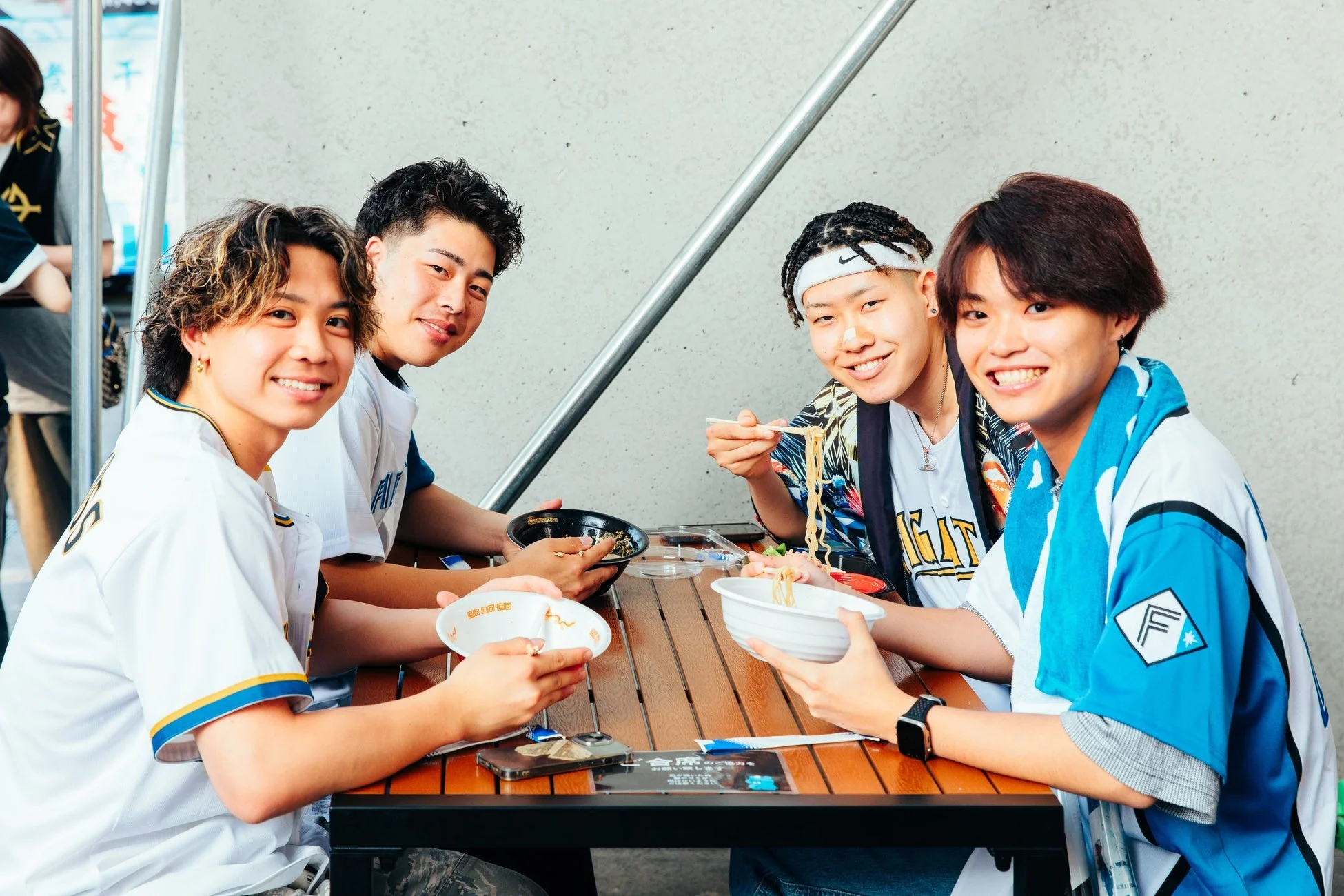 屋外でラーメンを楽しむ人々