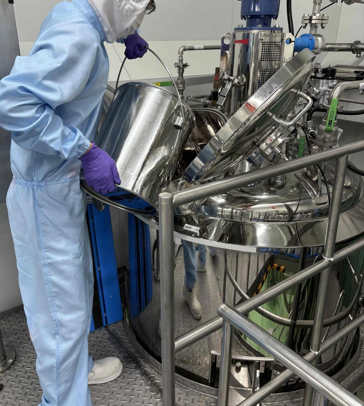 クリーンルームでの作業員とタンク