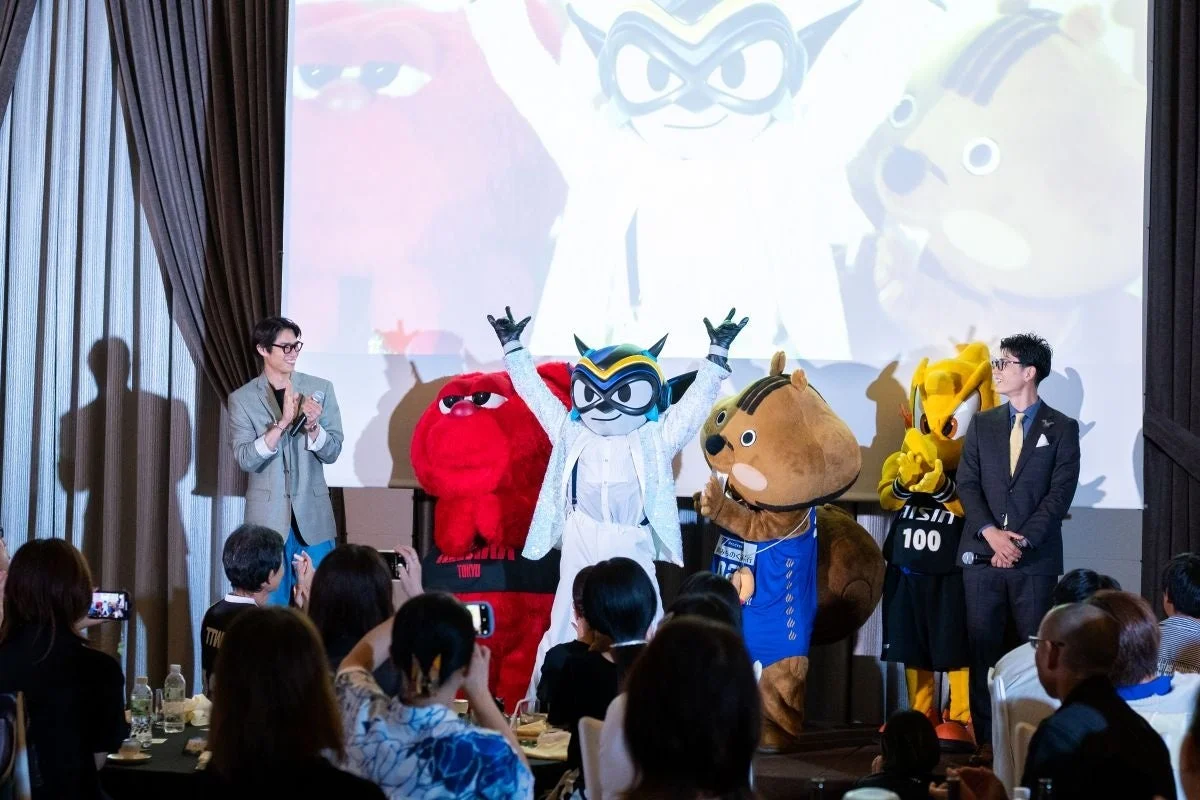 ステージ上のマスコットキャラクターと男性