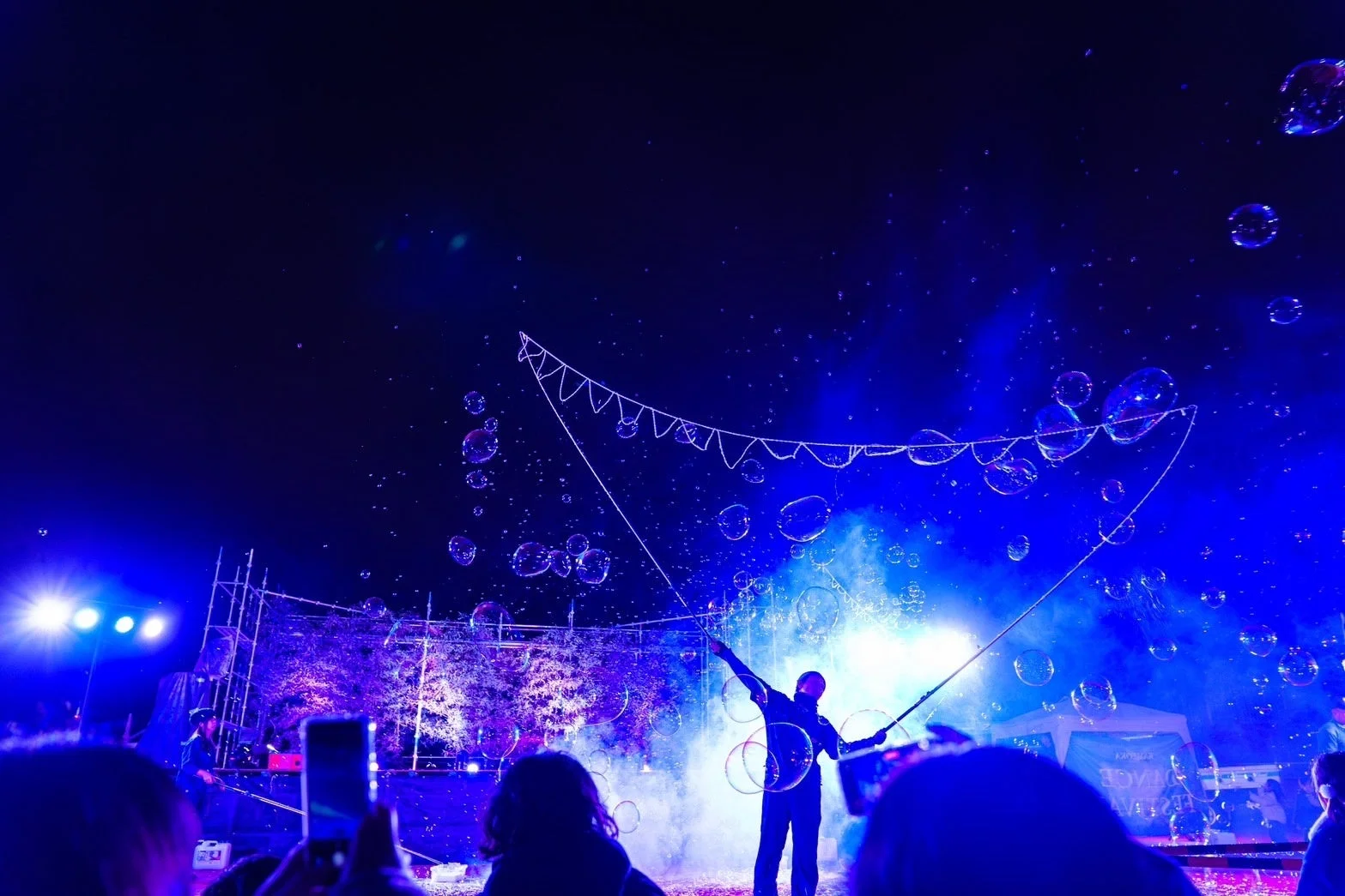 青い光の中のシャボン玉とパフォーマー
