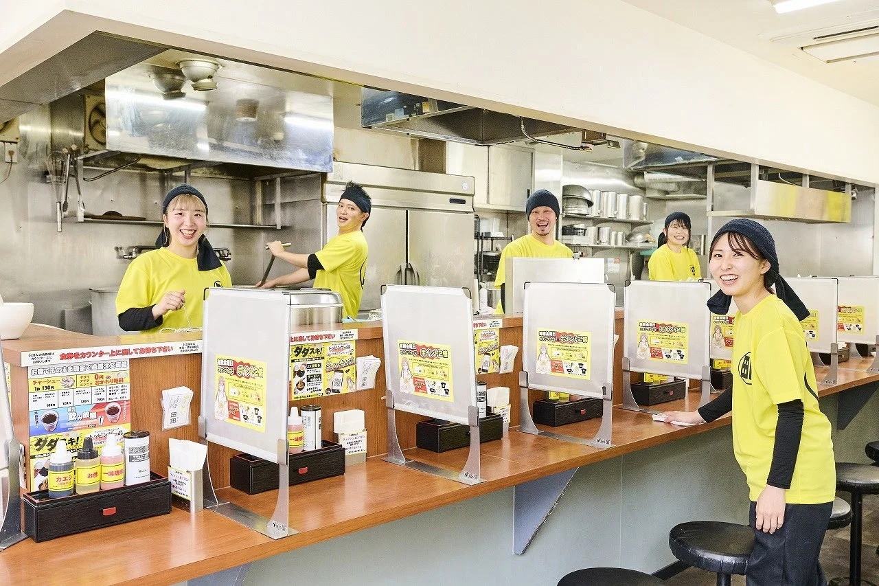 ラーメン店の券売機とスタッフ
