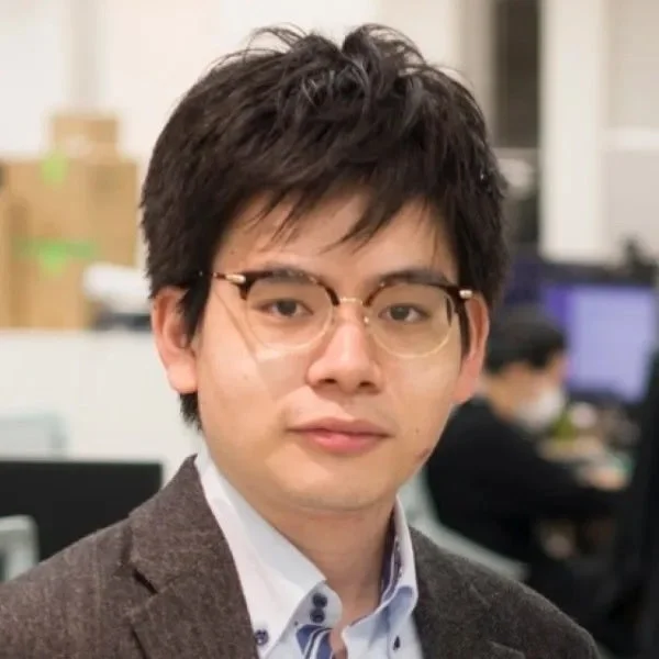 メガネをかけた若いアジア人男性のポートレートです。