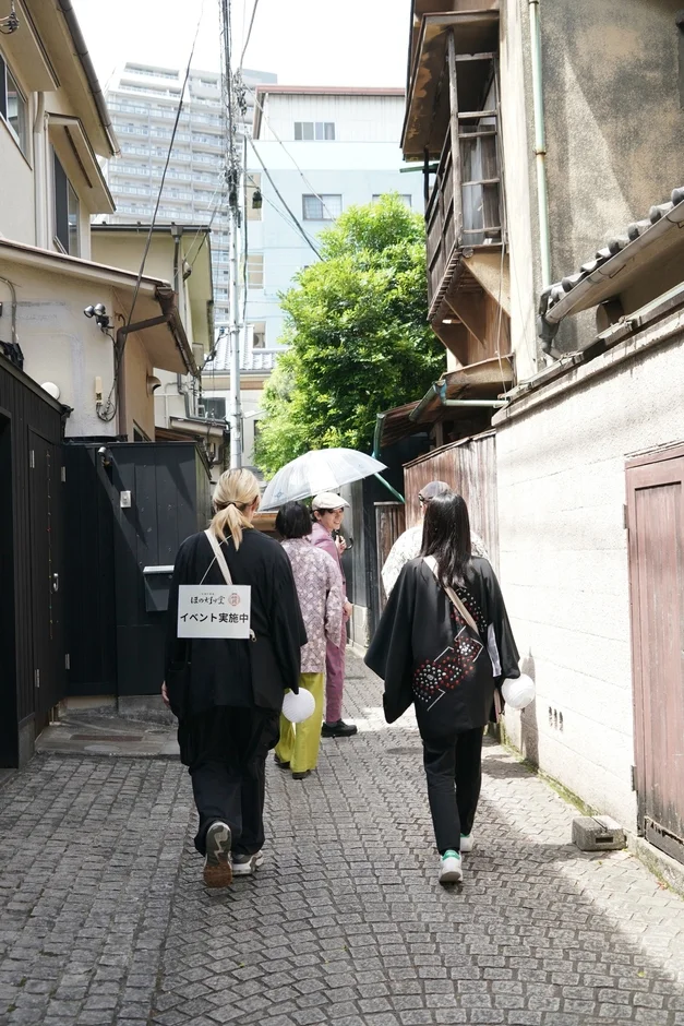 石畳の路地裏を和服姿のグループが歩く