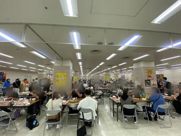 多くの人々が食事をしているイベント会場