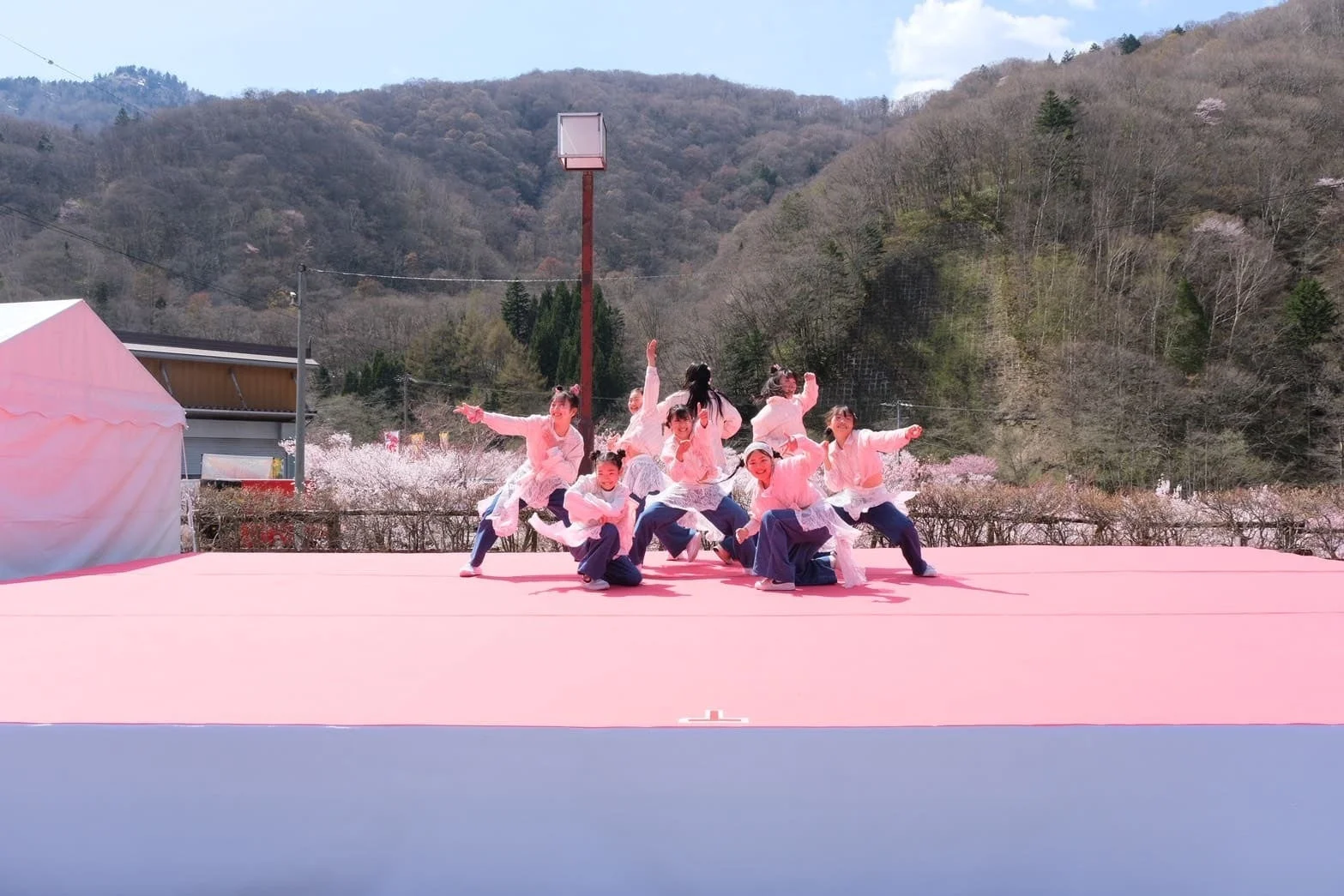 桜を背景にダンスを披露する若者たち