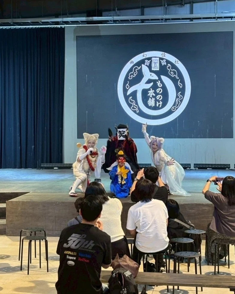 ステージ上で複数のコスチュームを着た演者がパフォーマンスをしている様子