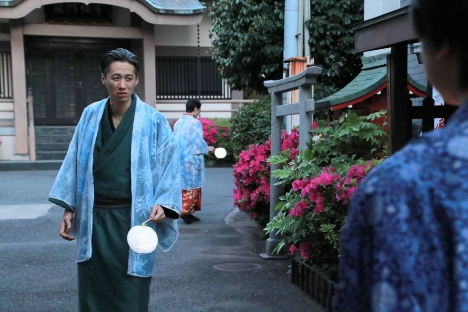 着物姿の男女が提灯を持って寺院らしき場所を歩く