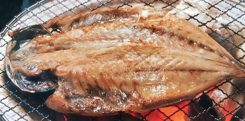 網の上でじっくりと焼かれた香ばしい焼き魚のクローズアップ
