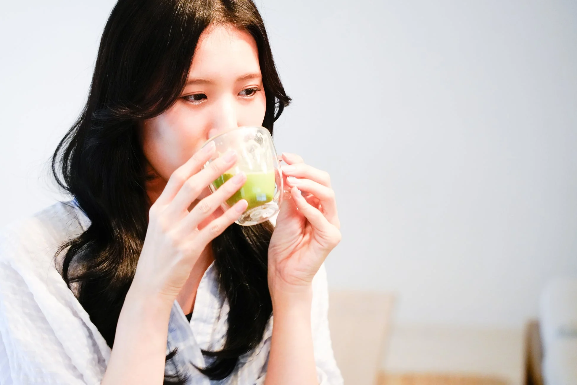 抹茶ラテを飲む女性