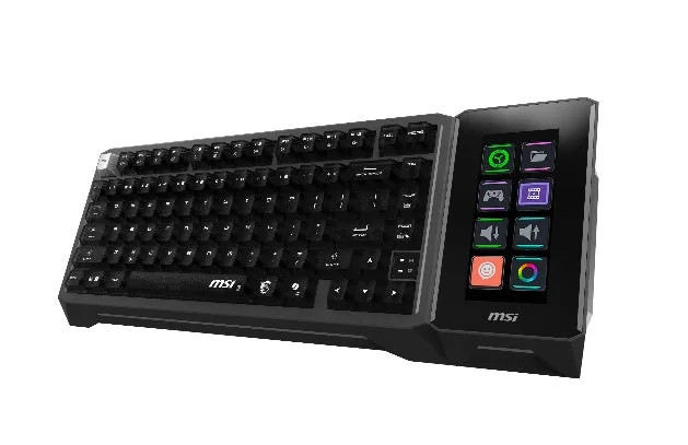 白い背景に置かれたMSI製の黒いゲーミングキーボードです。右側にはカスタマイズ可能なディスプレイ付きマクロパッドがあり、複数の機能アイコンが表示されています。ゲーマー向けの多機能デバイスです。