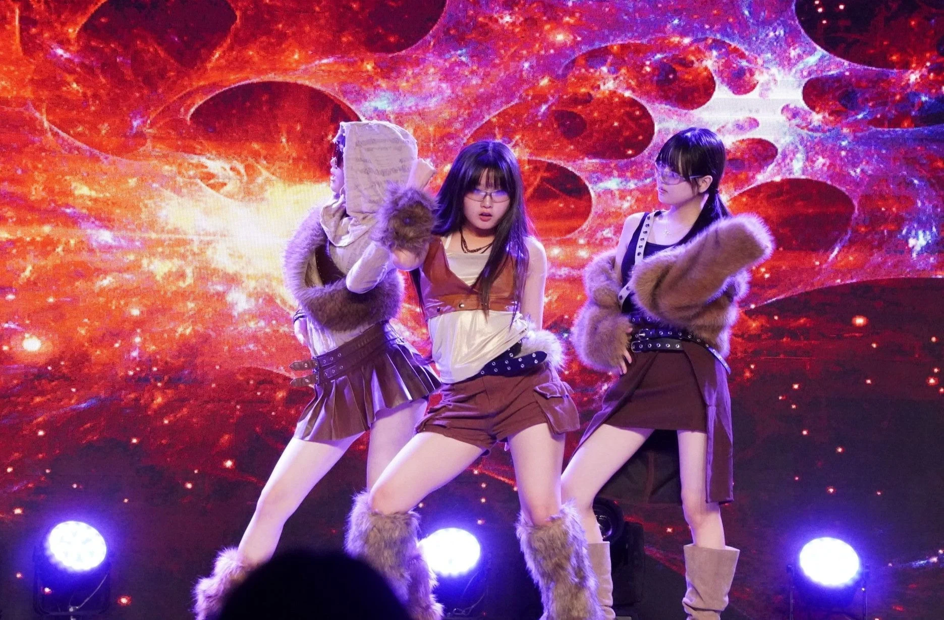 ライブステージでパフォーマンスする3人の女性