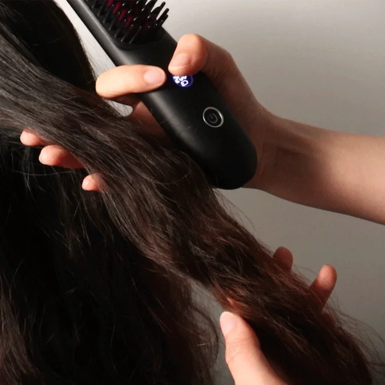 女性がヘアアイロンブラシを使用している様子