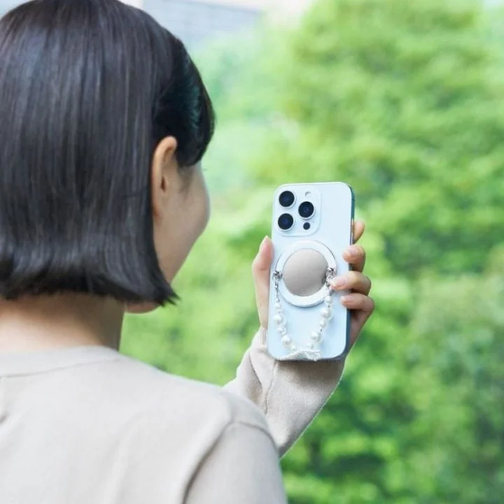 女性がミラー付きスマホリングを持っている後ろ姿