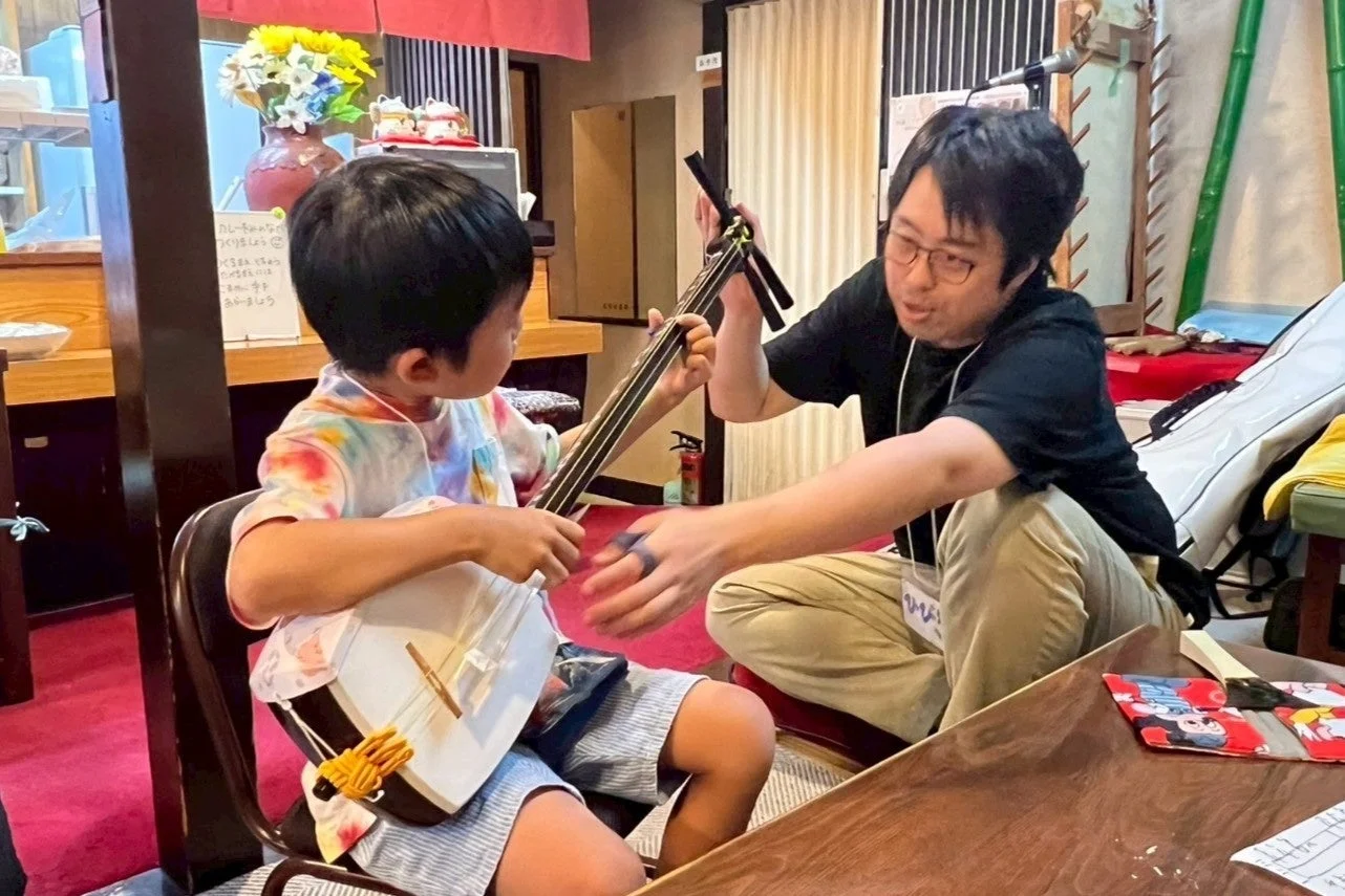三味線を教わる子供