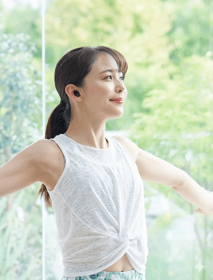 ヨガをしている女性がワイヤレスイヤホンを装着している様子