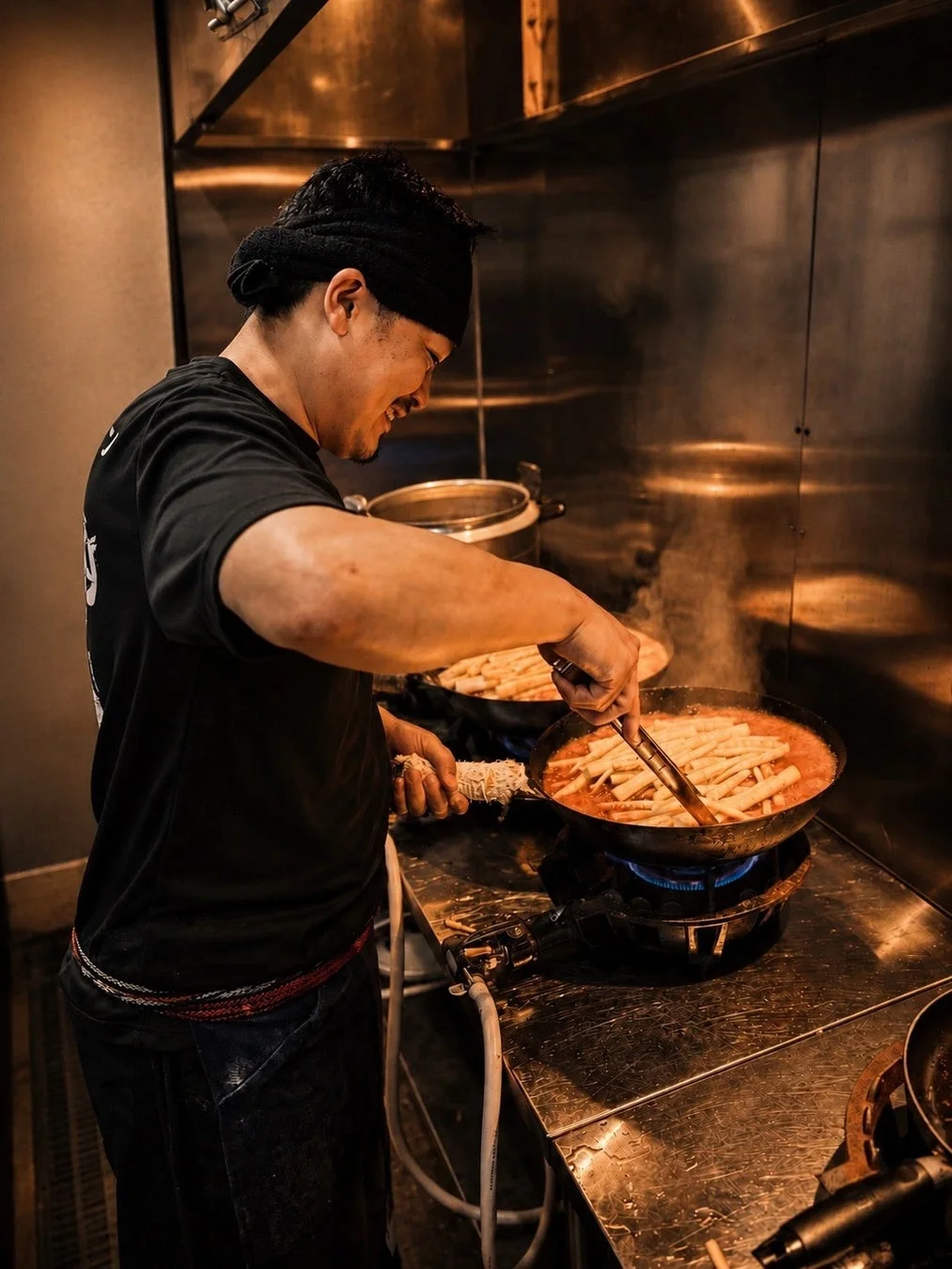料理人がフライパンで調理