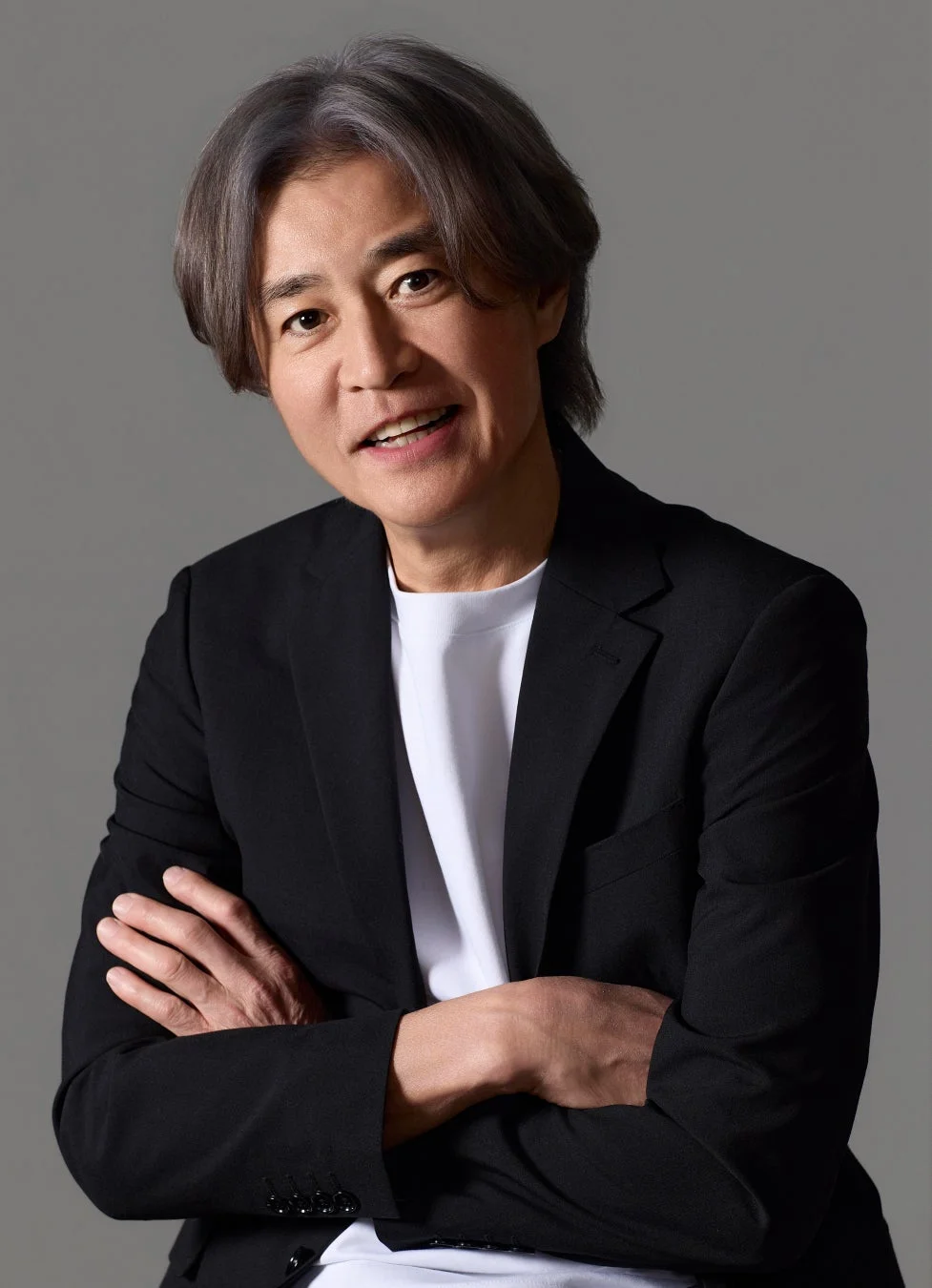 腕を組み笑顔でカメラを見る野々村真さん