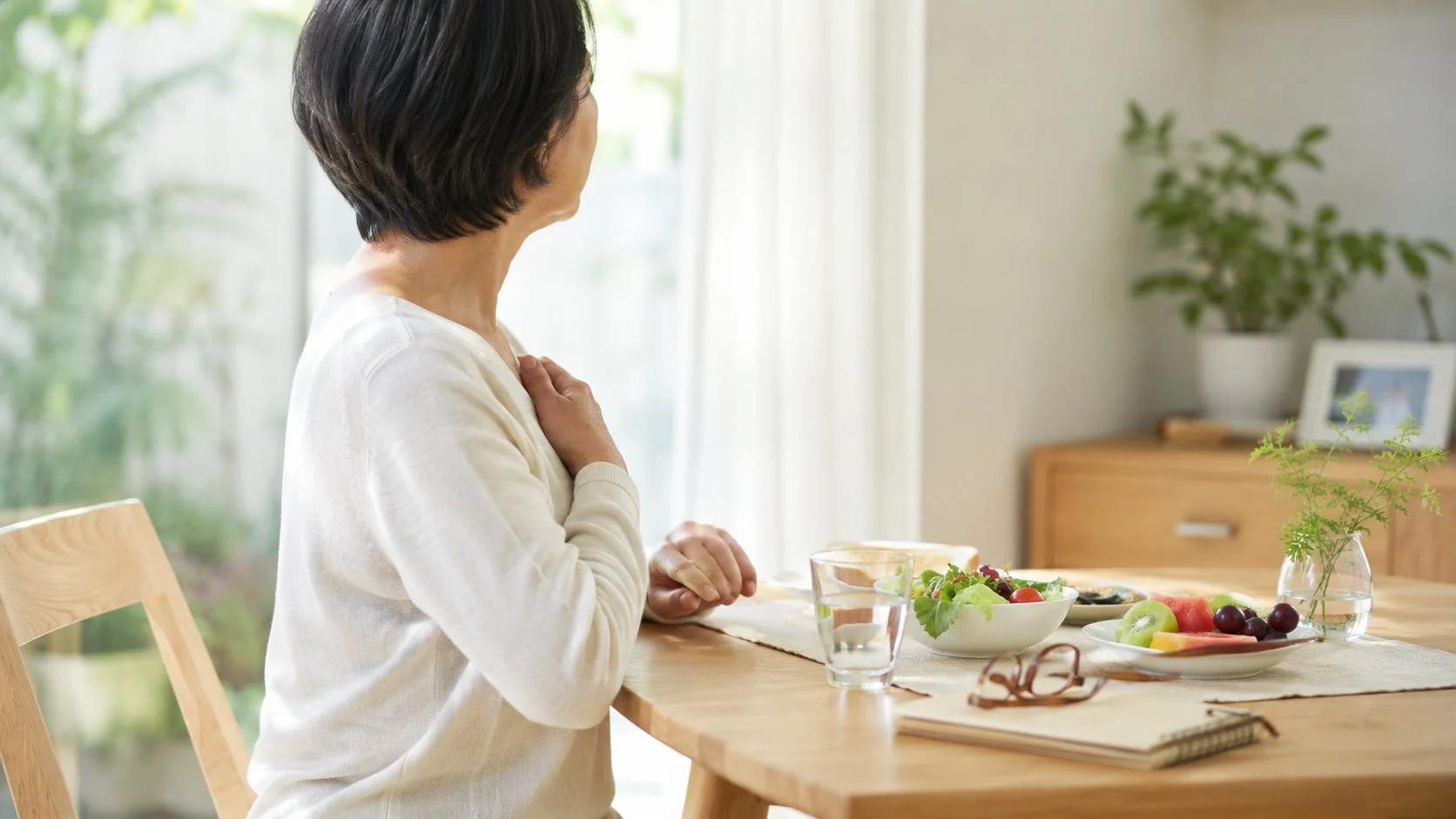 窓辺で朝食をとる女性