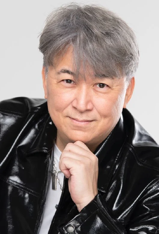 顎に手を当てて微笑む嶋大輔さん