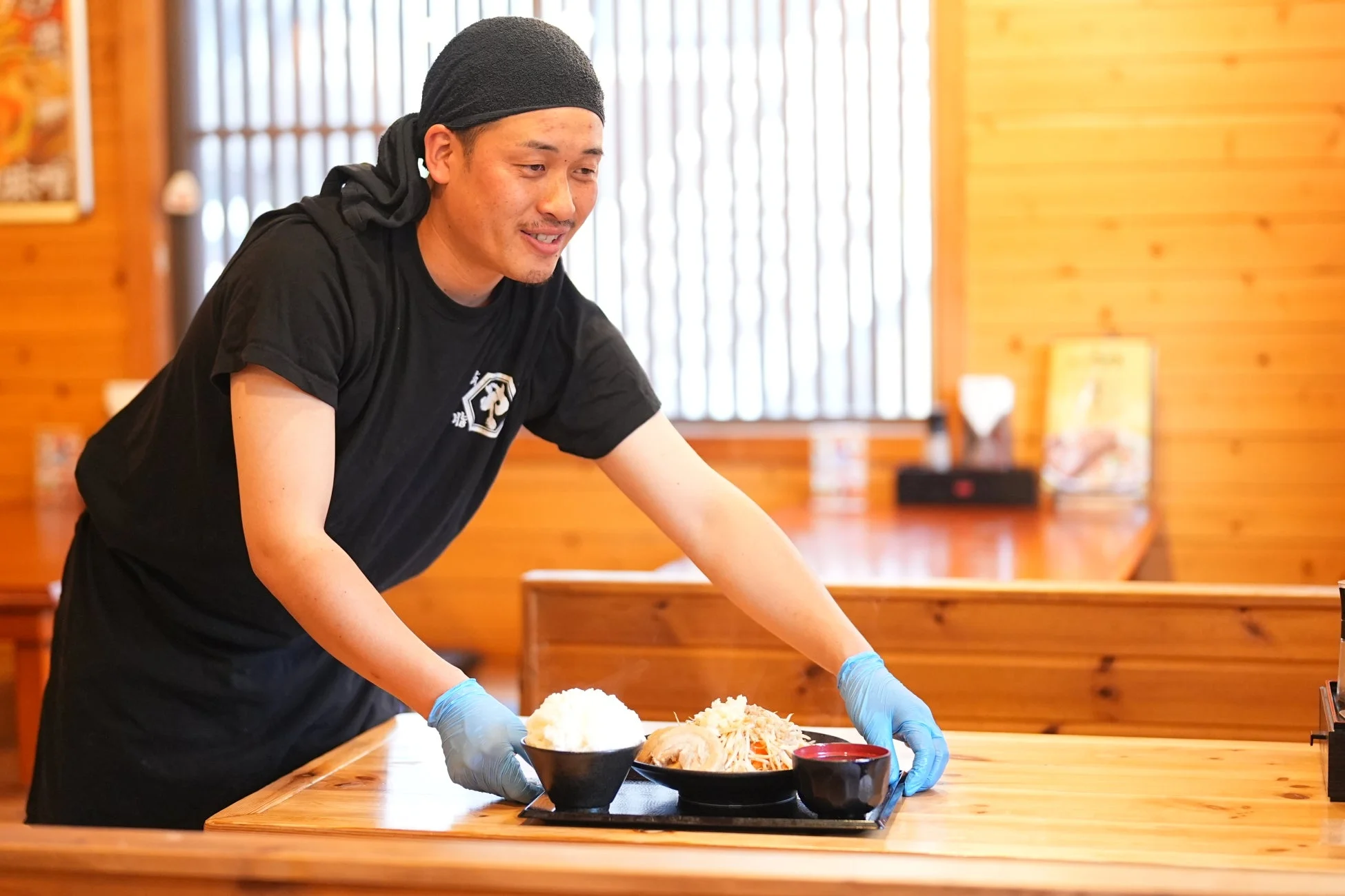 飲食店で定食を配膳する男性店員