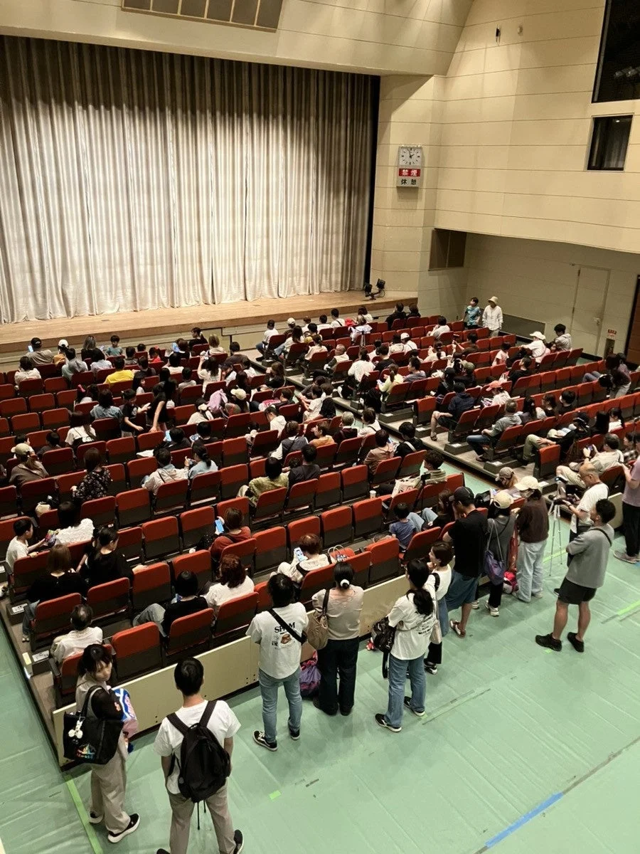 講堂でステージを鑑賞する人々