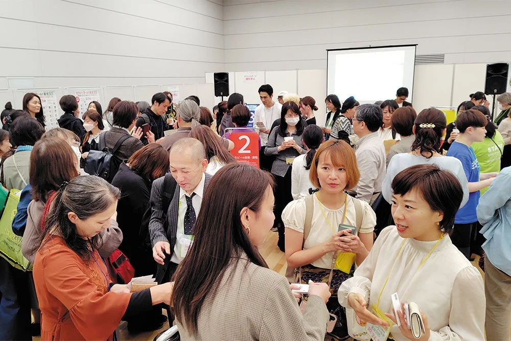 屋内イベント会場で多くの人々が交流している様子