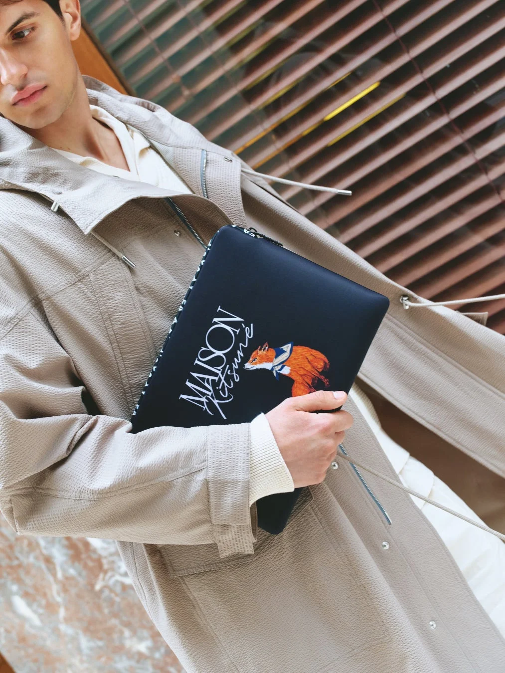 Maison Kitsunéのドキュメントケースを持つ男性