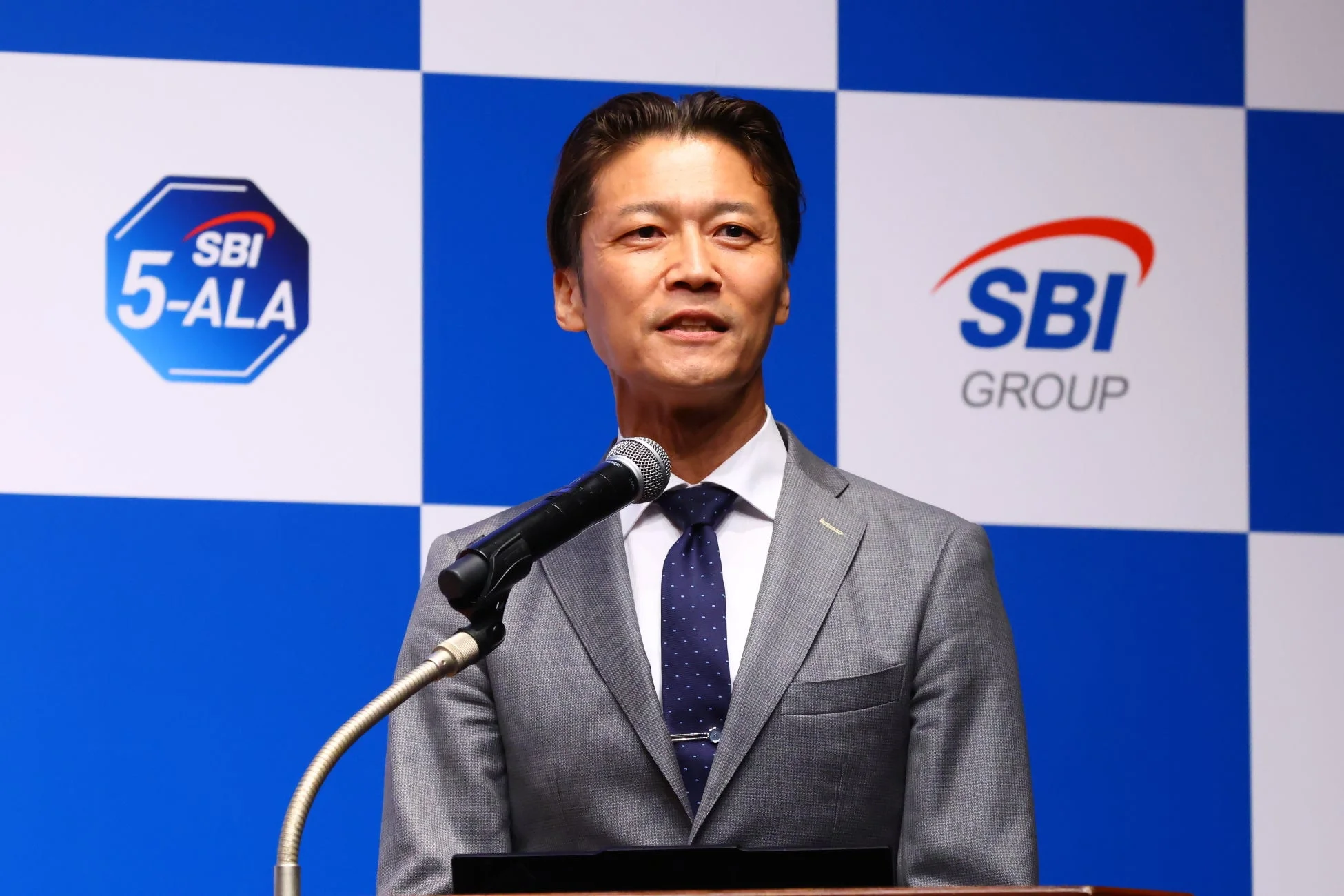 SBIアラプロモ社長の竹崎泰史氏がプレゼンテーションを行う様子