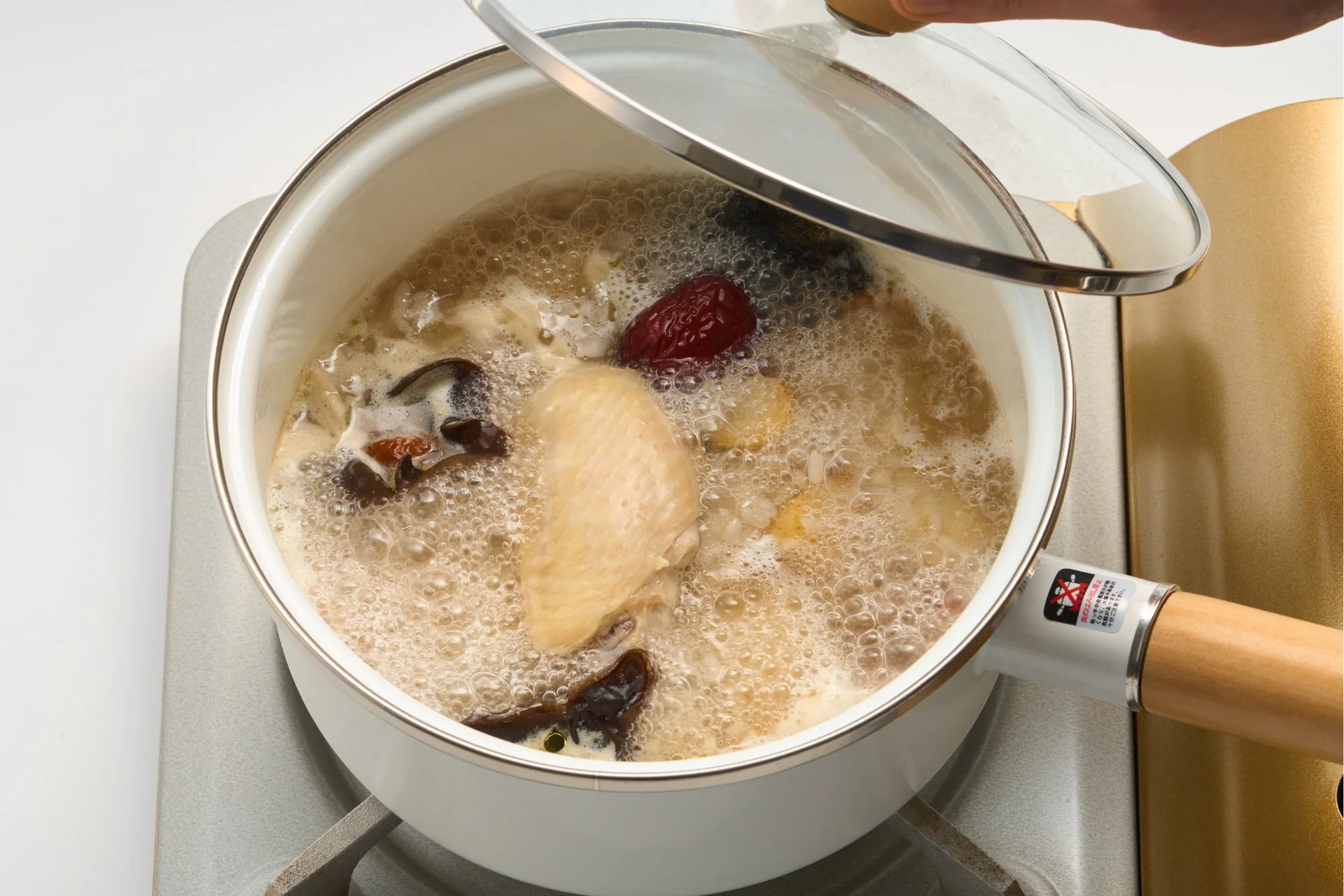 煮込んでいる様子、蓋が浮いている