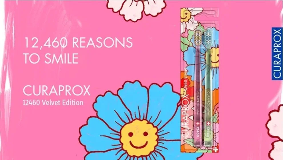 ピンクの背景に笑顔の花のイラストが描かれ、CURAPROX 12460 Velvet Editionの歯ブラシ2本セットが写っています。