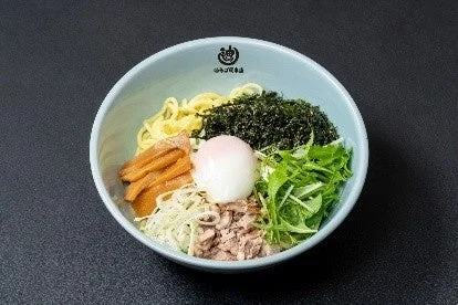 様々な具材が盛り付けられた、彩り豊かなまぜそばの画像です。温玉、メンマ、海苔、水菜などが食欲をそそります。