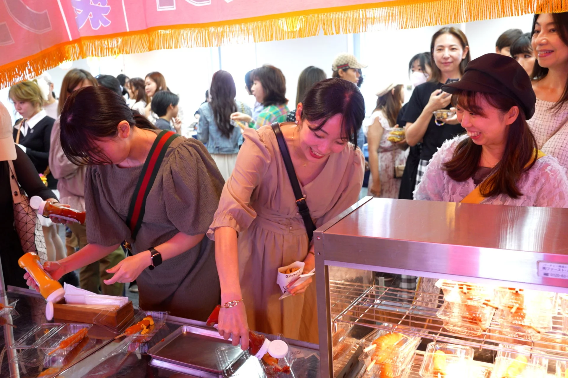 フランクフルトに調味料をかける女性たち