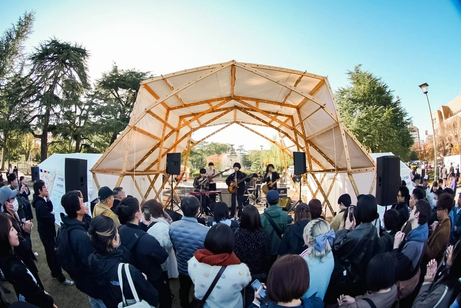 晴れた青空の下、公園のような屋外でバンドが演奏するライブイベント
