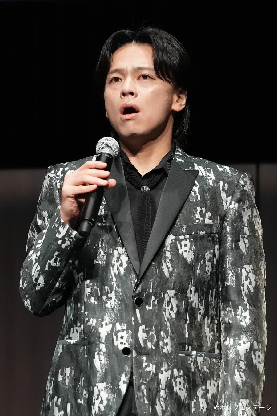 マイクを手に話す市村正親さんの姿