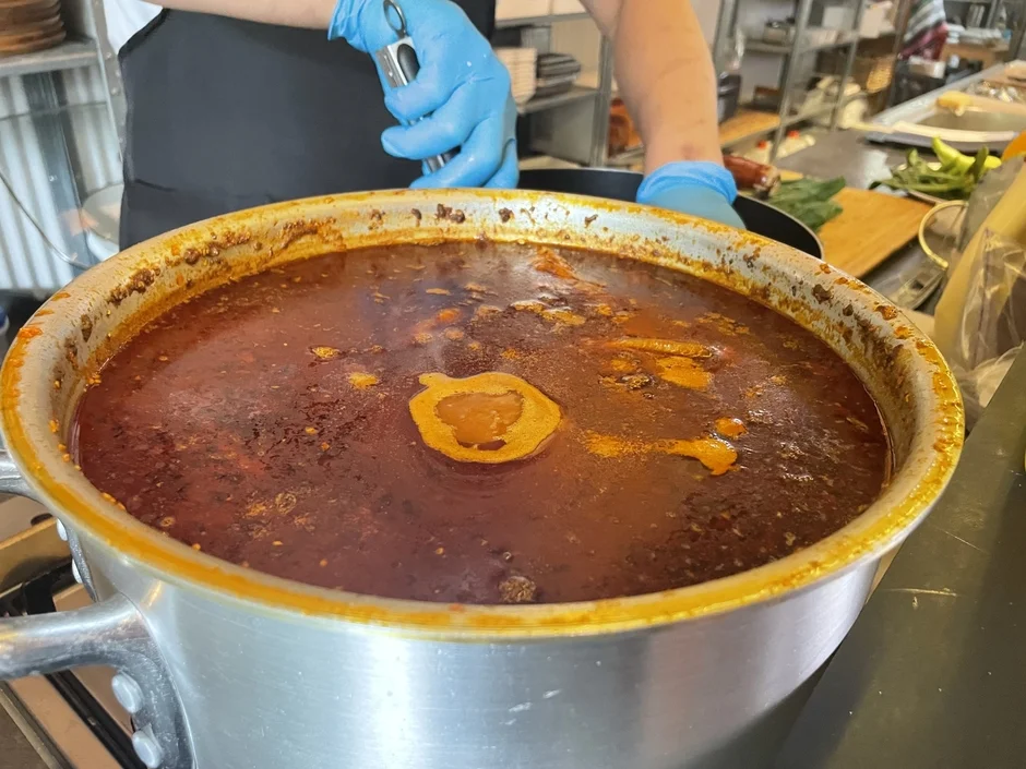 厨房で煮込み料理をかき混ぜる様子
