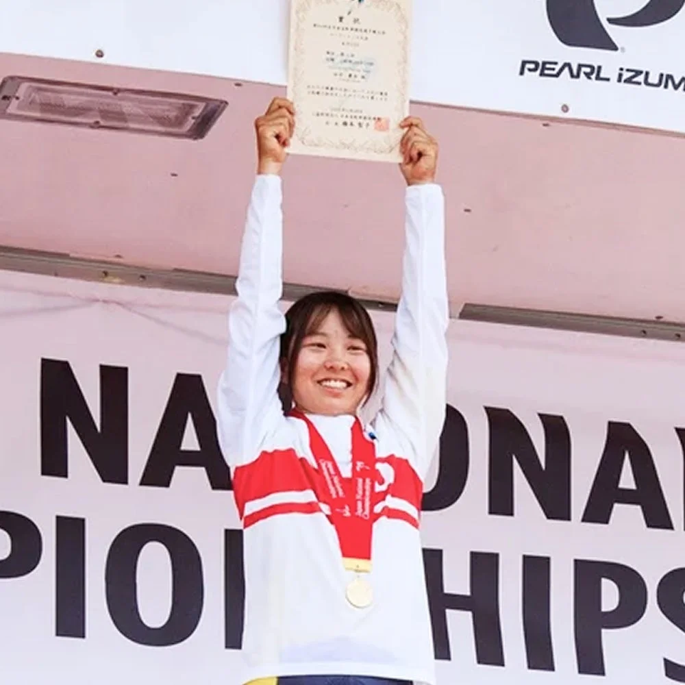 表彰台で賞状を掲げ笑顔を見せる田中麗奈選手