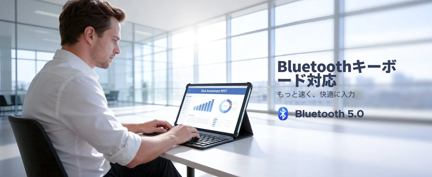 明るいオフィスで男性がBluetoothキーボード付きタブレットで作業中。