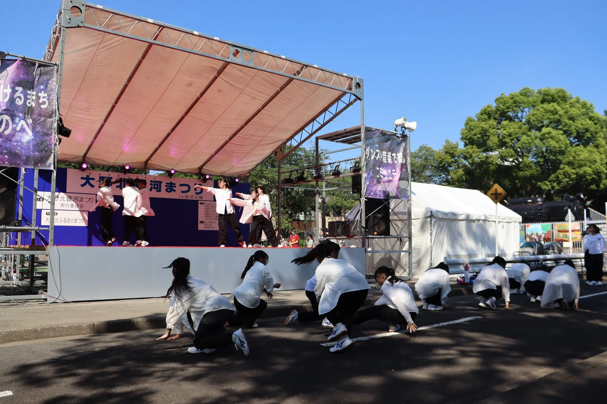 屋外ステージでダンスパフォーマンスを披露する若者たち