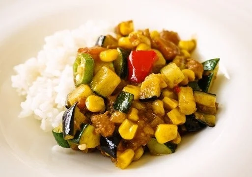 ナス、ズッキーニ、オクラ、パプリカ、コーンなどの色鮮やかな夏野菜がたっぷり入ったカレー